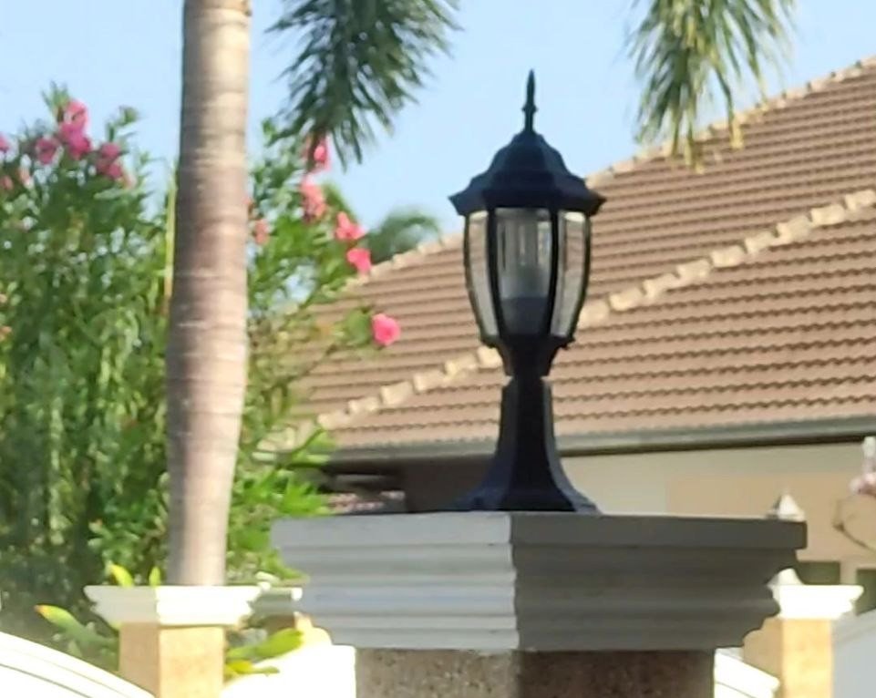 Picture of a light fitting on a column in what appears to be a Thai garden